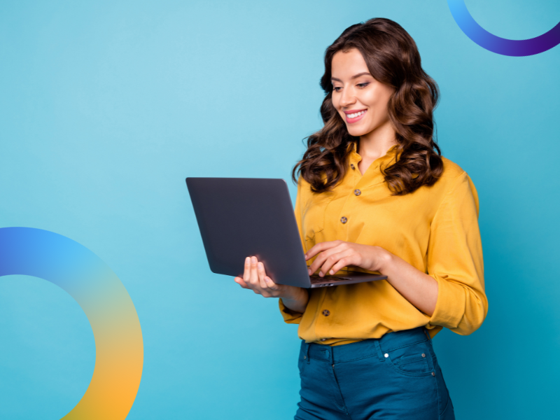 A woman in yellow accessing the internet on a laptop