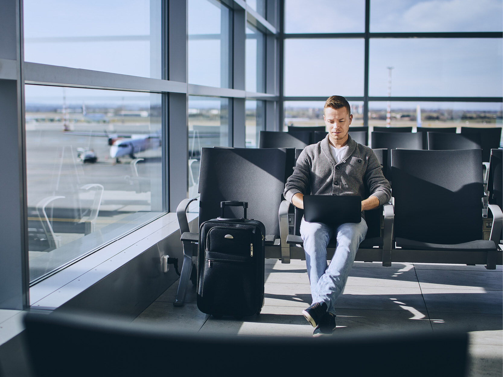 Travelers using laptop in airport