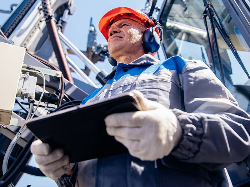 Focused employee working on the field using a tablet